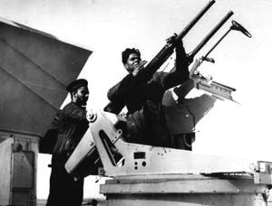 Two crew of HMIS Narbada cleaning a twin Oerlikon gun